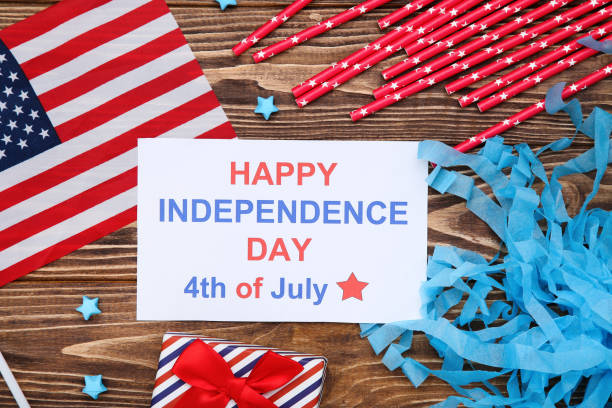 istock Text Happy Independence Day with flag, gift box and red straws on wooden background 2129666492