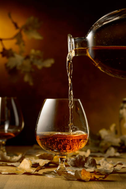 istock Cognac is poured into a glass from a bottle. 2129699104
