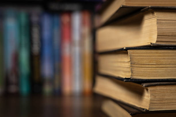 istock Book stack in the library room and blurred bookshelf for business and education background, back to school concept 2129724198