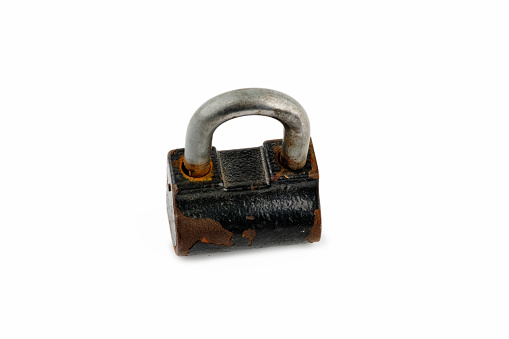 A close-up of a padlock with fragments of rust is closed. Top view on white