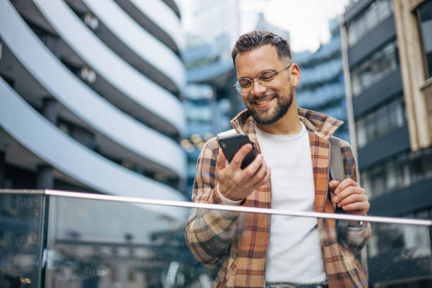 istock A man is walking down the street and using a smartphone. Around it are office buildings. 2129734254