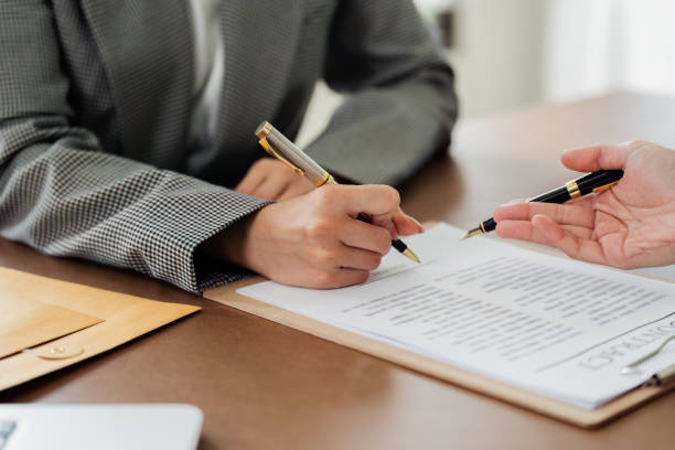 istock A woman is signing a document with a pen 2129749057