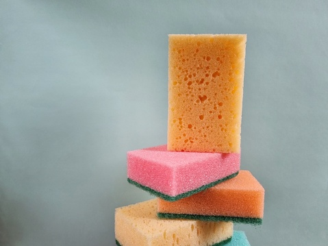 Stack of colored porous cleaning sponges close-up
