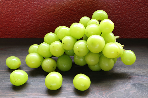 Bunch of Bright Yellow Green Fresh Ripe Shine Muscat Grapes on Wooden Table