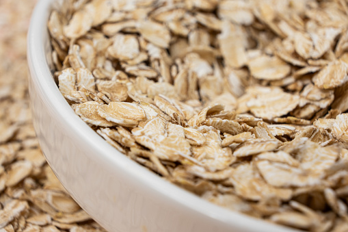 Dry uncooked oat flakes in a plate.