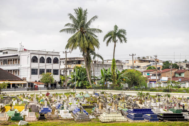 Masiid Raya Al-Mashun, Medan, Sumatra, Indonesia - January 16th 2024: View over a old cemetery with palm trees from the grand mosque
