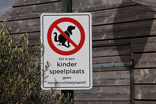 Warning on sign that children's playground is not a dog walking area in Dutch language in the Netherlands