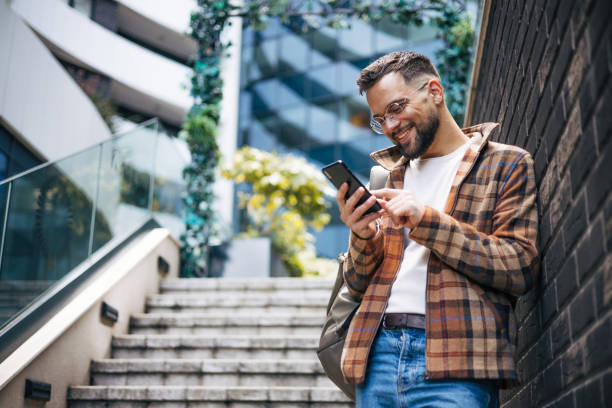 istock A man uses a smartphone to send messages on the street. 2129765925