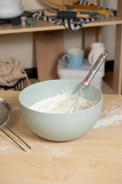 istock Dough kneading bowl and whisk on kitchen table. 2129766960