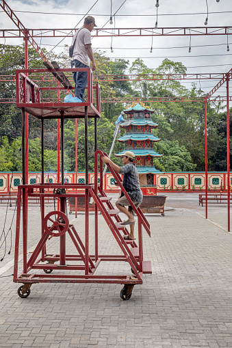 Vihara Gunung Timur Temple, Medan, Sumatra, Indonesia - January 16th 2024: Two men working on a scaffolding at the Buddhist - Confucian temple as part of preparing for the Chinese new year
