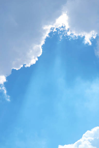 Sunny Blue Sky with Angel Ladder Beams Shining Through the Clouds