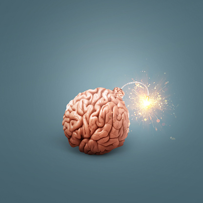 Creative brain bomb with a wick and sparks is lit on a dark blue background. Genius and idea, concept idea. Headache and stress. Science and education