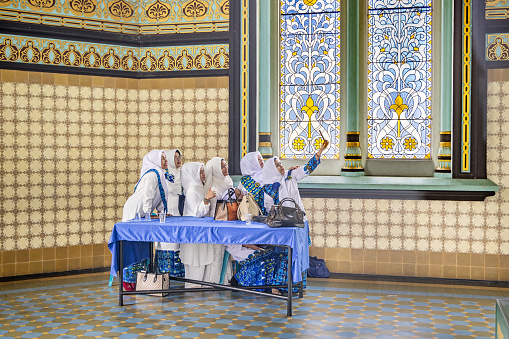 Masiid Raya Al-Mashun, Medan, Sumatra, Indonesia - January 16th 2024:  A group of women having fun and taking selfies after the prayer in the grand mosque