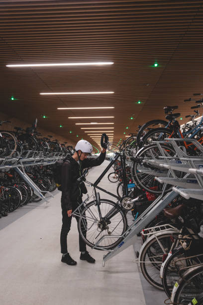 istock Traveller is surprised by the huge underground cycle station under the main overpass in Amsterdam, Netherlands. Inserting the wheel into the attachment and bike handle 2129782294