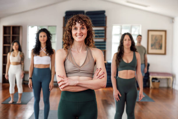 istock Yoga instructor smiling at camera with her team 2129792327