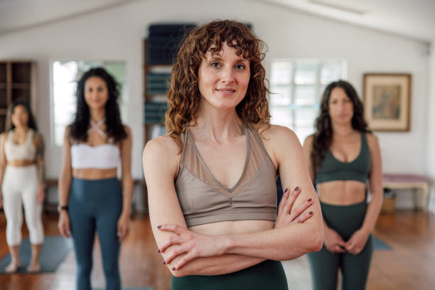istock Yoga instructor smiling at camera with her team 2129793597