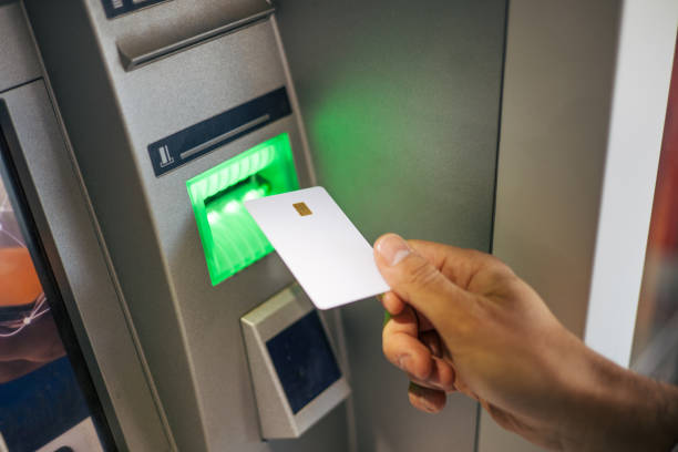 istock Close-up image of a man's hand inserting a credit card into an ATM. 2129797022