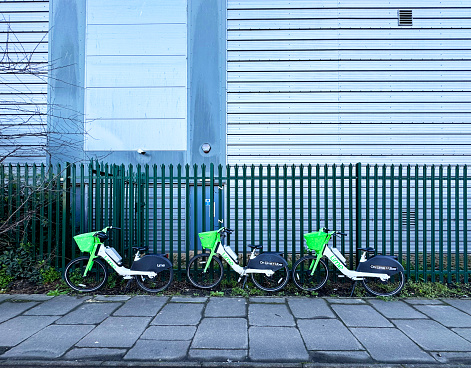 Lime electric hire bikes parked across the pavement on an industrial estate in Tottenham Hale in North London. march 2024