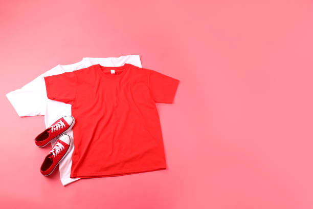 istock Blank t-shirts and sneakers on pink background 2129817996
