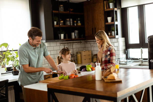 istock Joyful Family Prepares Breakfast Together in a Sunlit Modern Kitchen 2129821668