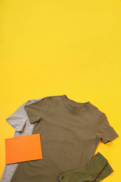 istock Blank t-shirts, socks and space for text on yellow background 2129830452