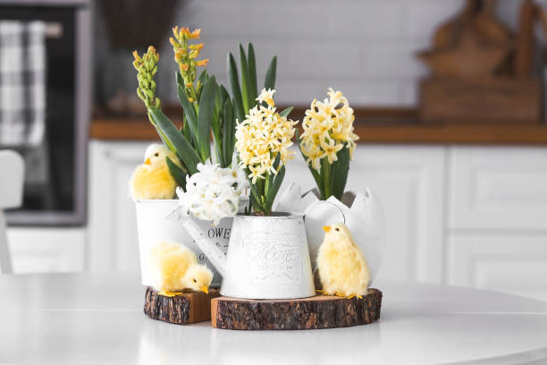 istock Happy Easter. Spring yellow hyacinth flowers in an egg-shaped vase, chicken chicks on a white table. In the background is a white Scandinavian-style kitchen. Easter decor in the house. 2129832656