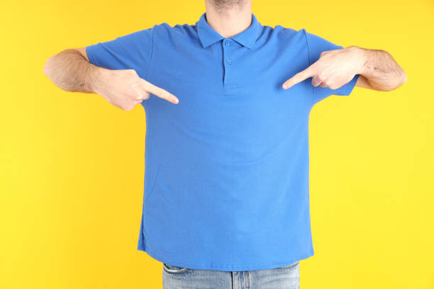Man in blank blue polo on yellow background