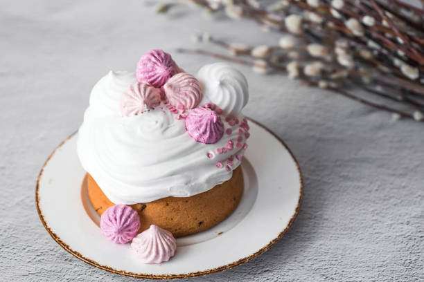 istock Beautiful stylish still life. Easter cake with meringue, marshmallows, Easter eggs and willow twigs on a light concrete background. happy Easter 2024. 2129836440
