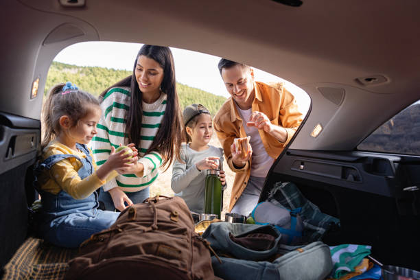 istock Parents with daughters having an snack, from the car trunk 2129845473