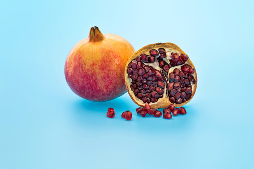 One and a half pomegranates on red background.