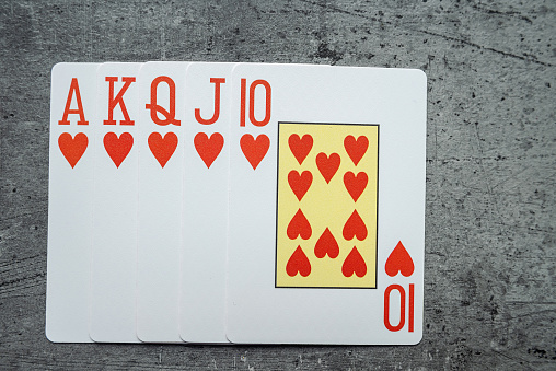 Set of Heart Royal flush playing cards on grey desk. Gambling concept