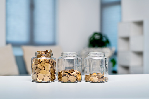 Three jars with coins on the table.