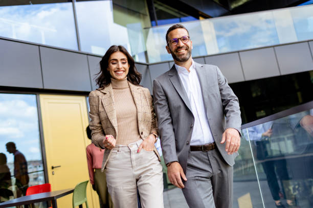 istock Cheerful Colleagues Exiting a Modern Office Building on a Bright Afternoon 2129868919