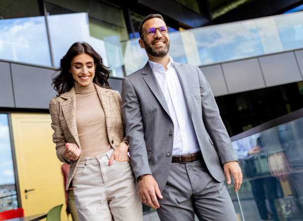 istock Cheerful Colleagues Exiting a Modern Office Building on a Bright Afternoon 2129868938