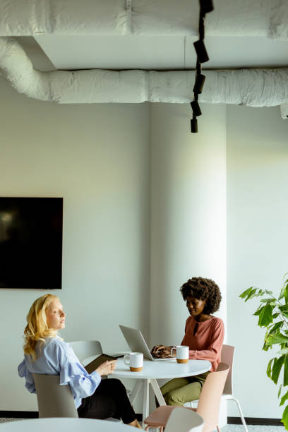 istock Joyful Office Coffee Break With Colleagues Sharing a Laugh in Bright Workspace 2129868957