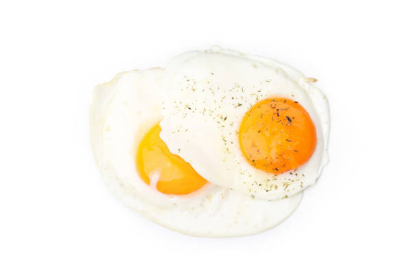 istock Fried eggs with spices isolated on white background 2129877035