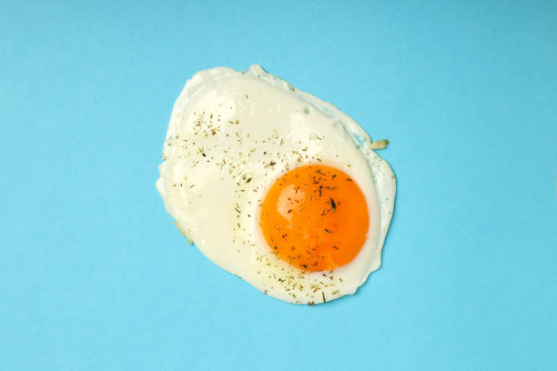 istock Fried egg with spices on blue background, top view 2129877311