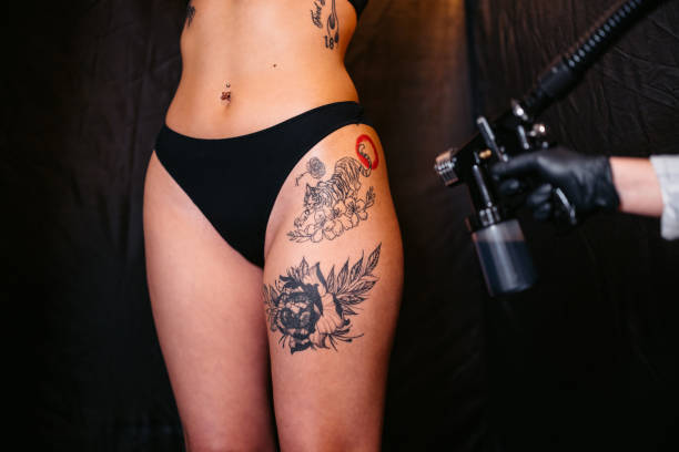 Young woman getting a spray tan at the beauty salon. Close-up.
