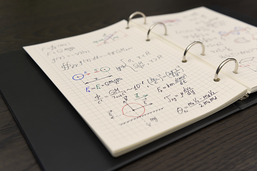 A detailed physics notebook reveals a myriad of handwritten equations and diagrams, showcasing a deep dive into complex mathematical concepts