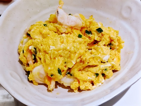 fresh scrambled eggs on white plate on breakfast table