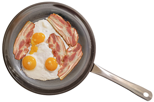 Traditional gourmet breakfast, with three delicious organic Sunny freshly fried side up eggs, and bunch of pork belly bacon slices, prepared in the new, modern, large, heavy duty, non-stick ceramic coated black frying pan, isolated on white background, viewed directly above.