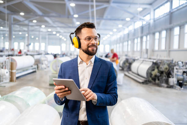 istock Factory manager in business suit controlling production process on his tablet computer. 2129897429