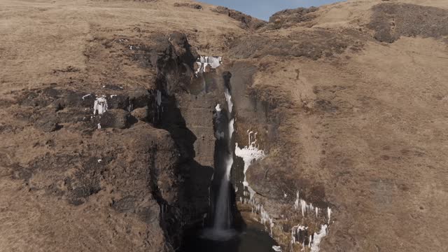 Aerial shot moving downwards whilst in front of a Gluggafoss waterfall, Iceland