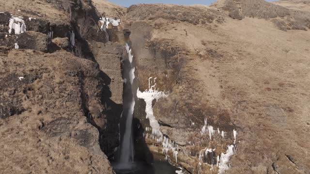 Aerial shot moving downwards whilst in front of a Gluggafoss waterfall, Iceland
