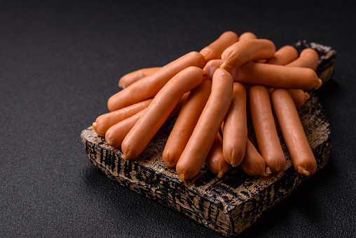Stock photo showing close-up, elevated view of raw, home-made, pork sausages spread out in rows on a blue metal baking tray, ready to be put in a preheated oven.