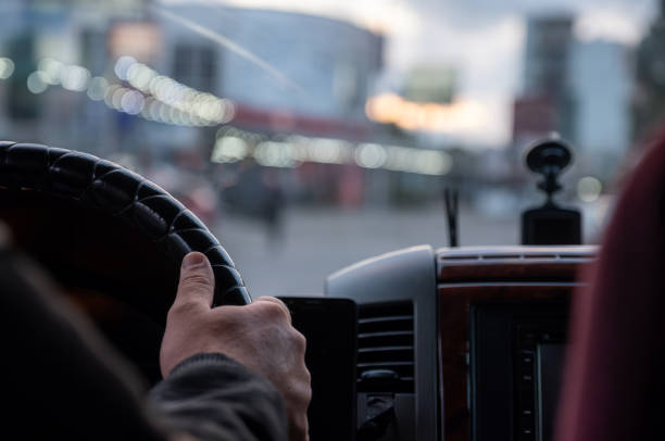 istock old man hands while driving on road with blurred lights and cars traffic 2129948842