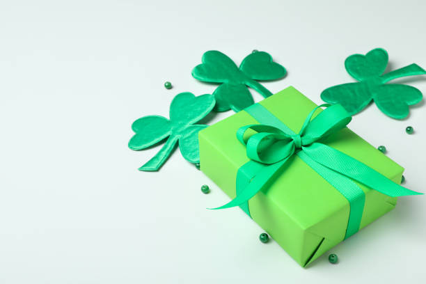 istock Clover leaves, gift box and beads on white background 2129956416