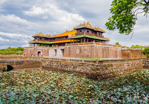 Tourists sightseeing the imperial citadel of Hue entering through the meridian gate, Vietnam