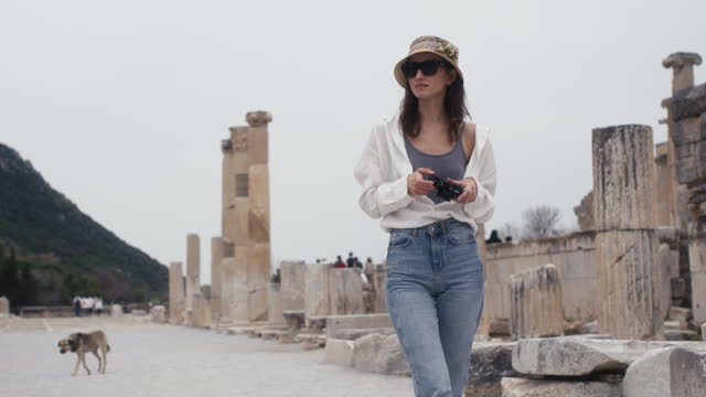 Slow motion portrait of young tourist woman in a historical archeological ancient town ruins.