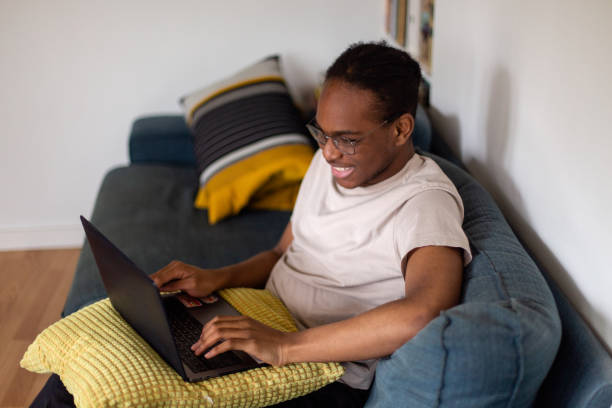 istock Professional happy young Black man working from home, using laptop computer in living room 2130012169